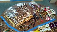 Overview of costume jewelry collection including necklaces, brooches, earrings and rings arranged on a table.