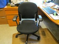 Black Herman Miller rolling computer chair in office setting showing front view with cushioned seat and armrests