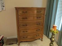 Front view of the 5-drawer chest showing the decorative metal handles and carved drawer fronts.