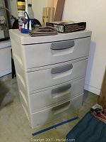 Full image of closed white Sterlite 4-drawer storage cabinet with items on top