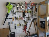 Pegboard view showing Ryobi blower and assorted hand tools hung on hooks