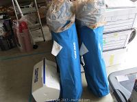 Two blue Quick Shade canopy chairs packed in blue carry bags alongside one blue Playmate cooler with a white lid.