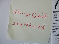 Photo of a paper note with dimensions of storage cabinet written as 25 x 4.5 x 71.5 inches