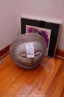 Two-piece lot shown with framed decor print and concrete sun face sculpture on wood floor near wall.