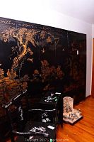 Full view of eight-panel black lacquered folding screen with gilt nature scene