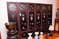Six-panel dark stained carved wood folding screen with black lacquer panels featuring assorted jade and stone inlays
