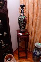 Full view of wooden stand with vase on top, showing overall proportions.