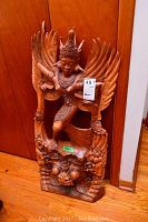 Full front view of entire wood carving leaning against door