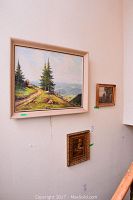 Photo showing three paintings on wall: large Black Forest landscape and two smaller oil paintings.