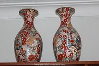 Photo of two matching Asian style porcelain vases side by side showing overall shape and design.