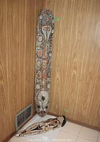 Both masks leaning against wood-paneled wall corner