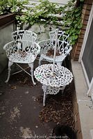 Overview of three chairs and side table on balcony showing wear and layout