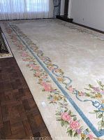 Large oriental area rug with floral design on cream background, showing size and overall condition on floor.