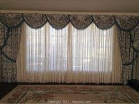 Full view of drapery set installed across window, showing ivory sheers behind printed drapes and valance