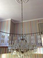 Chandelier hanging from ceiling medallion, chain visible