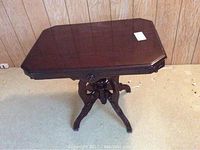 Full view of the dark wood Victorian style occasional table with octagonal top and four curved legs.