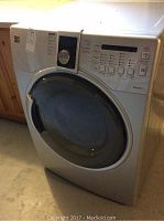 Front and angled view of silver Kenmore steam dryer showing door and control panel