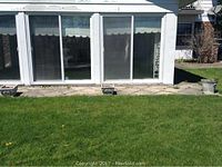 Three cement flower urns outside along patio in front of windows