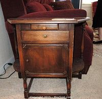 Front view of dark-stained wooden humidor cabinet showing drawers, cabinet door, and wood grain.
