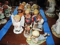 Overview of seven porcelain figurines on wooden table