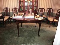 Full view of mahogany finish dining table with cabriole legs in room setting
