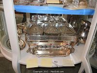 Front view of the large chafing dish with three glass inserts, warming indicator windows, and a decorative serving tray below it.