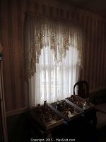 Full view of small window setup with lace valance and sheer panels