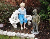 Side angle showing both lawn statues with boy, dog on bench, and standing boy