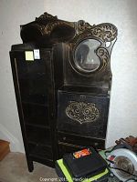 Full view of side by side oak piece showing left tall glass-door bookcase and right carved desk with mirror