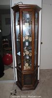 Tall hexagonal framed glass front cabinet filled with steins and other items.