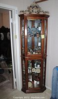 Full view of the corner curio cabinet showing overall form and finish