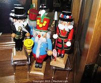 Front angle view of three Steinbach limited edition nutcracker figurines arranged on clear stands, showing detailed paint and accessories.