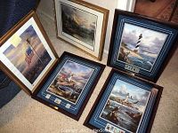 All five framed prints displayed on floor, showing lighthouse prints with stamps and Thomas Kinkade prints