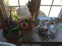 Overview of six flower pots, vases, and decorative items on tabletop near window
