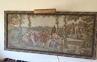 Full view of the framed tapestry with mounted light showing the entire artwork and frame.