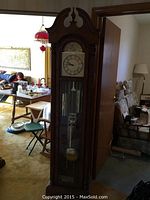 Full view of oak floor clock showing arched bonnet top and base