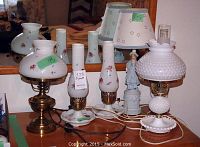 All three lamps together: two kerosene style glass lamps and one figurine lamp with shade