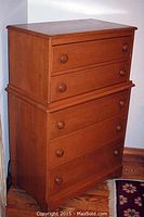 Full view of a 5-drawer dresser made of wood with a maple finish, showing its overall shape and size.