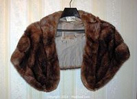 Front view of brown mink fur stole showing overall condition and shape on hanger.