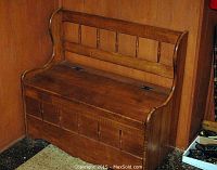 Front view of wooden bench closed, showing slatted backrest and chest front panels.