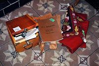 Overview of wooden case with cutting machine, hooked rug, pattern templates, and books
