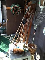Image of wooden garden tools, hand tools, ladder, bench, rake, and wicker basket