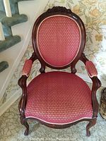 Front view of entire chair showing carved crest, upholstery and legs