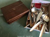 Wooden case closed next to box of utensils