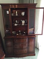 Front view of two-piece china hutch with glass doors, drawers and cabinets.