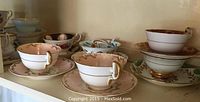 Shelf display of six bone china teacup and saucer pairs in various patterns