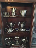 Overview of three shelves displaying all silverplated serving pieces
