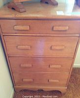 Front view of maple wood dresser showing four drawers with wooden handles.