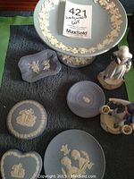 Full lot of Wedgwood jasperware items on cloth including pedestal dish, lidded dishes, soap dish, ashtray, small plate, two Dutch figurines
