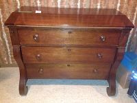 Front view showing three-drawer walnut desk with bracket feet and drop-front closed